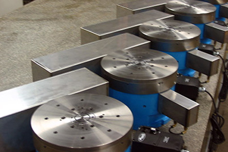 Close up image of a surface grinder grinding wheel spinning against a rotary grinding table producing sparks